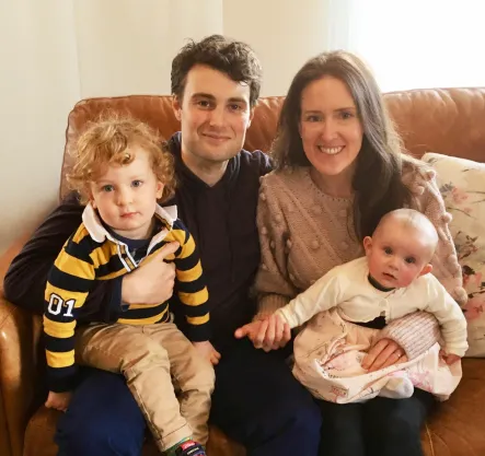 Eric with his wife and two young children on a sofa